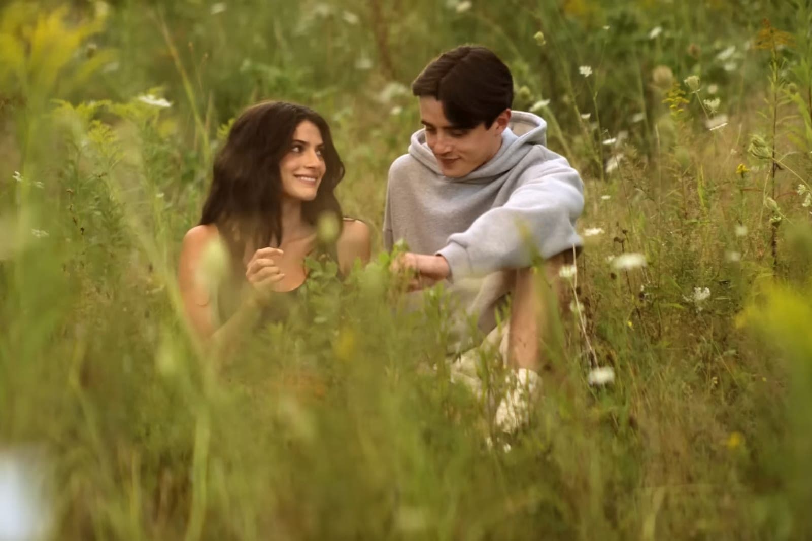 Two young characters sitting together in a wildflower field in Sterling Point