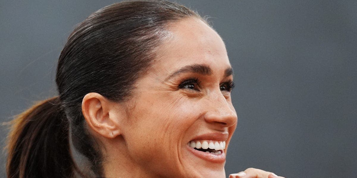 A manicured hand in Meghan Markle's strawberry milk nail polish shade