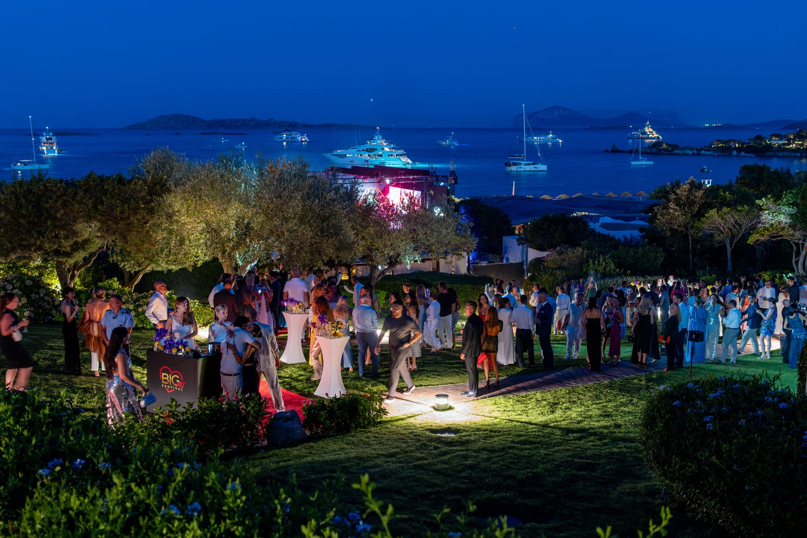 The gardens at Romazzino at blue hour with yachts anchored offshore
